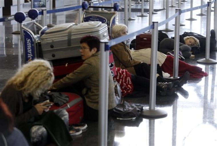 Passengers, stranded becuase of Iceland volcano distruptions, wait and sleep in a line at a Finnair counter at John F. Kennedy International Airport in New York on April 20, 2010. 